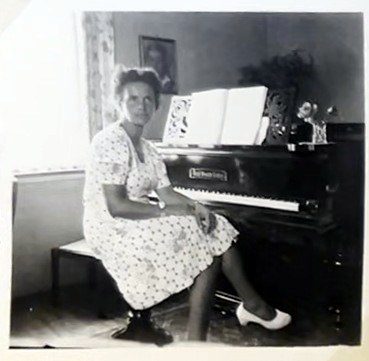 Frau sitzt am Flügel
