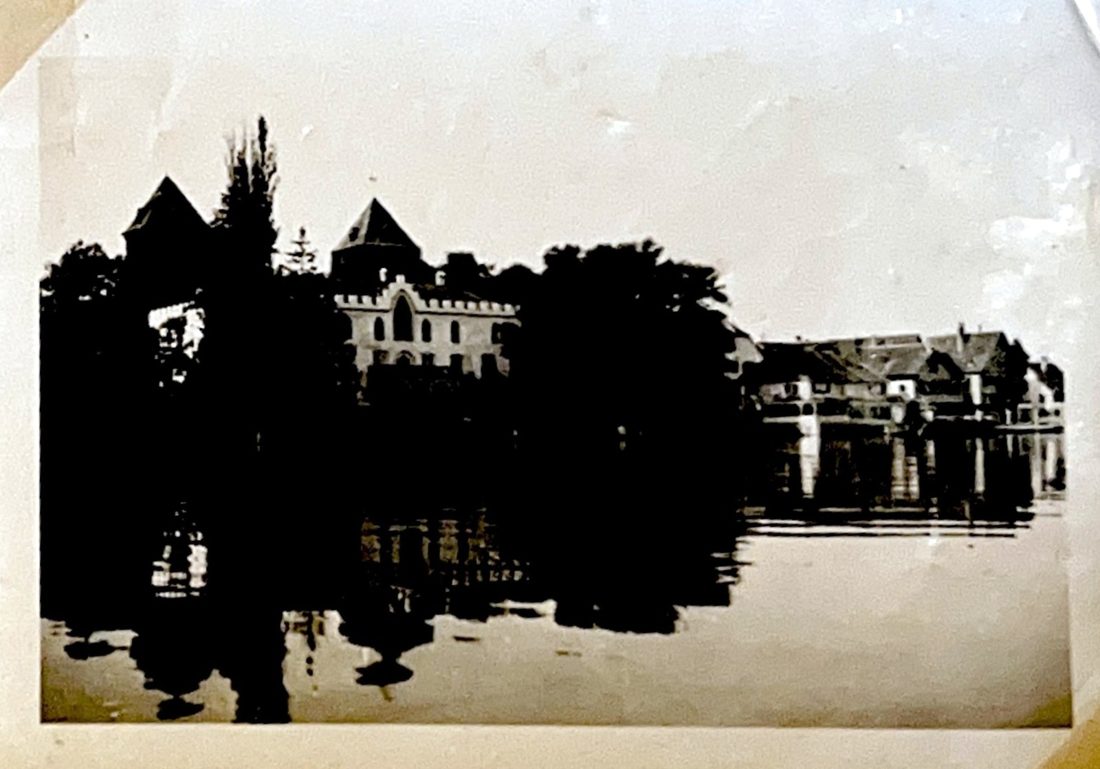 Gebäude und Bäume am Wasser im Gegenlicht